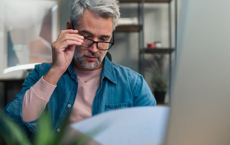 Man holding reading glasses while browsing options