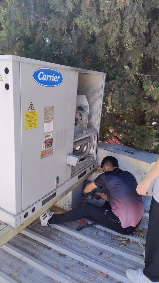 Técnico trabajando en una unidad Carrier de climatización durante una intervención