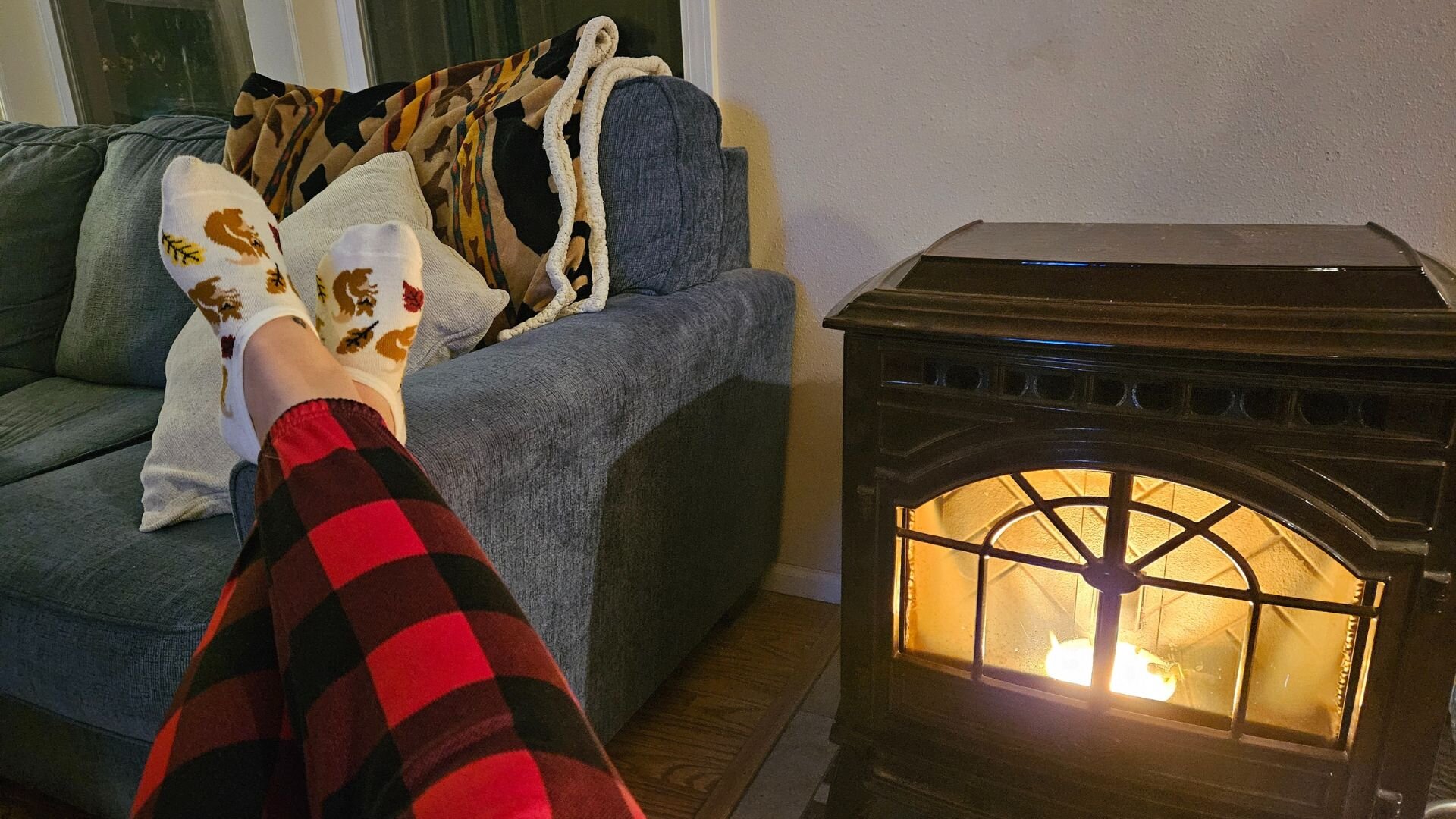 A woman lounging by her heating stove