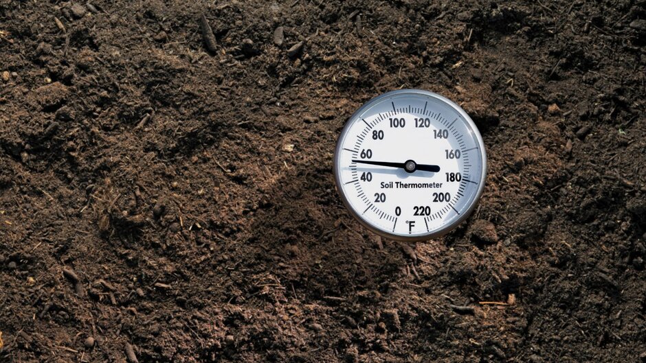 A soil temperature gauge in the ground is testing the temperature of the soil for planting.