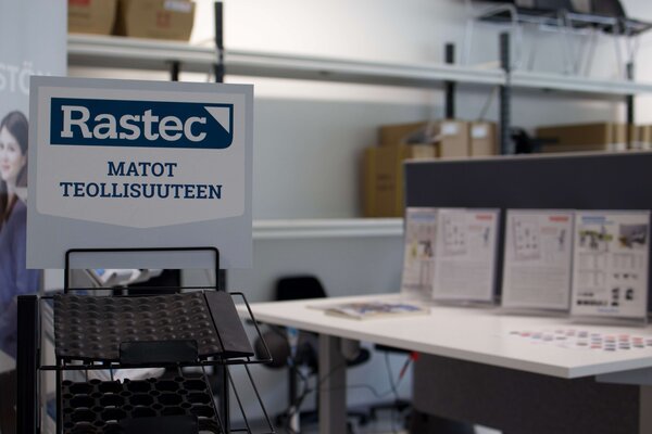 Rastec-teollisuusmattojen näyttelyalue, jossa on esitteitä ja mallikappaleita.