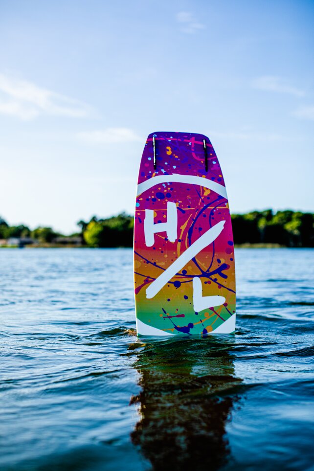 A Hyperlite wakeboard with HL logo appearing out of the water