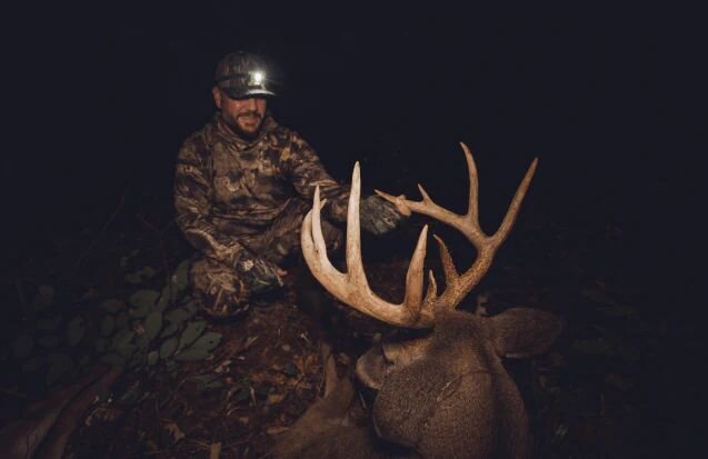 Two mature whitetail bucks spar at a deer mineral site with a Trophy Rock salt lick.