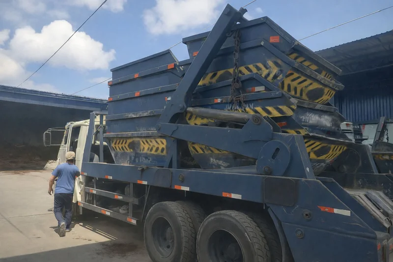 Caminhão entregando caçamba de entulho