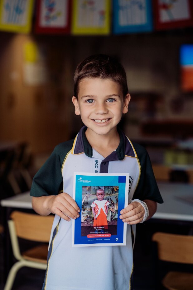 Student holding a booklet and smiling