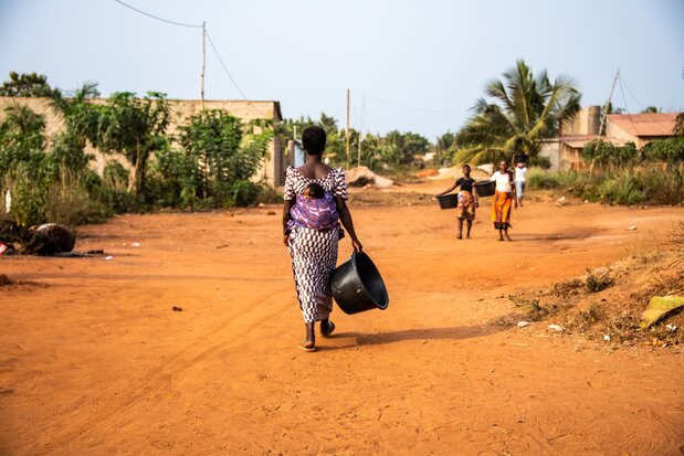 An African mother carrying a baby on her back