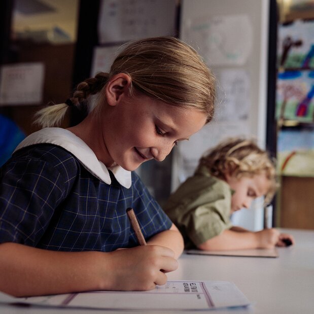 Student writing in a classroom