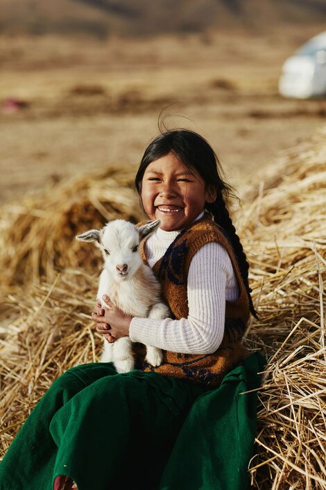 a girl holding a goat