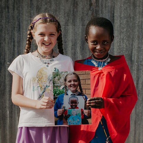 two smiling children holding a photo
