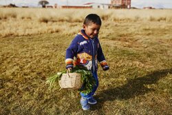 photo of Bolivian children holding a basket of vegetables