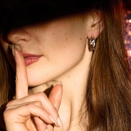 Malli pitää sormeaan huulilla tyssäävässä eleessä