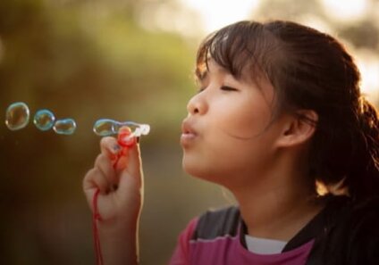 kid blowing bubbles