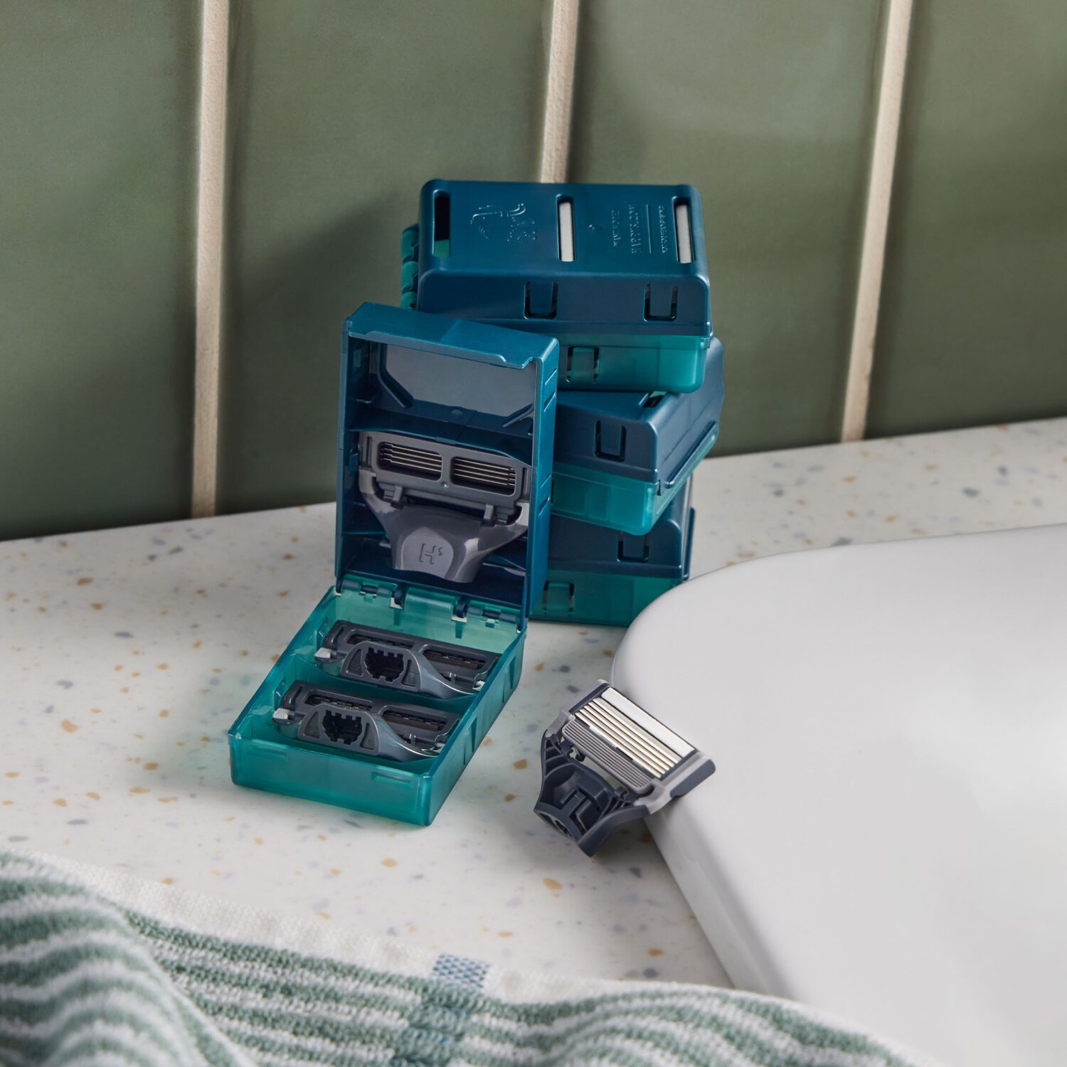 Sixteen Harry's Original razor blade cartridges stacked on a bathroom sink