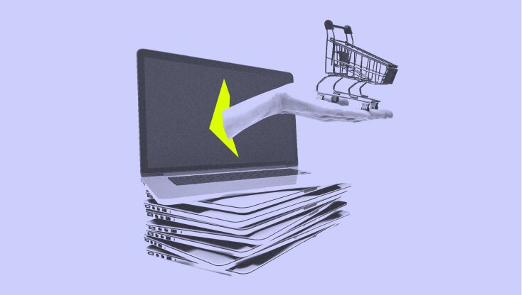 A laptop with a screen opened on a stack of other laptops. A hand is reaching out of the screen and holding a shopping cart.