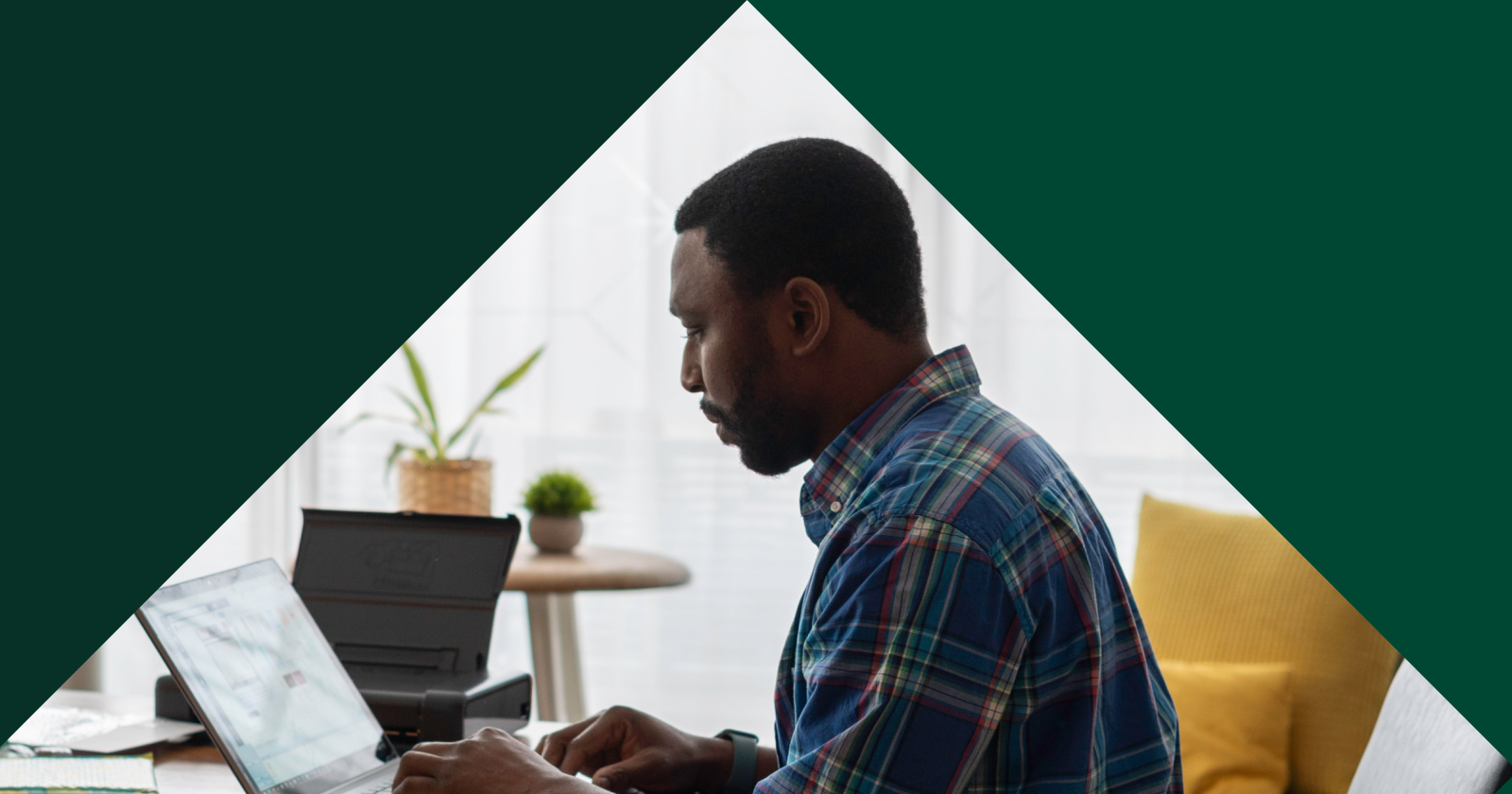 Diamond Image Within a Dark Green Background of the Side Profile of a Person Diligently Working on Laptop Computer