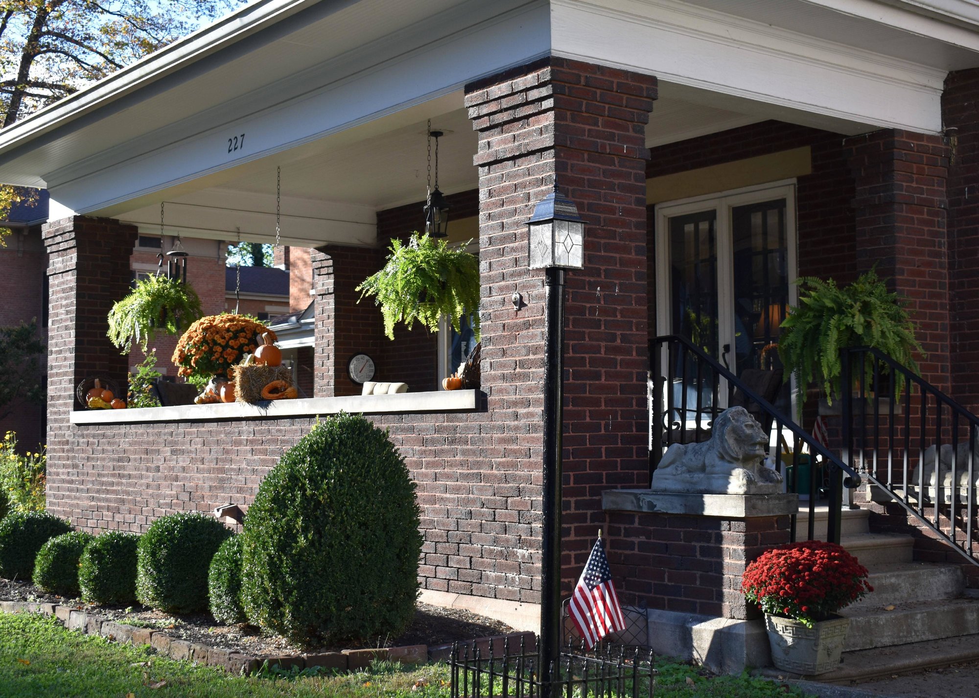 “Front porch of brick home with American flag in planter” - Source: Yana Smith // Shutterstock