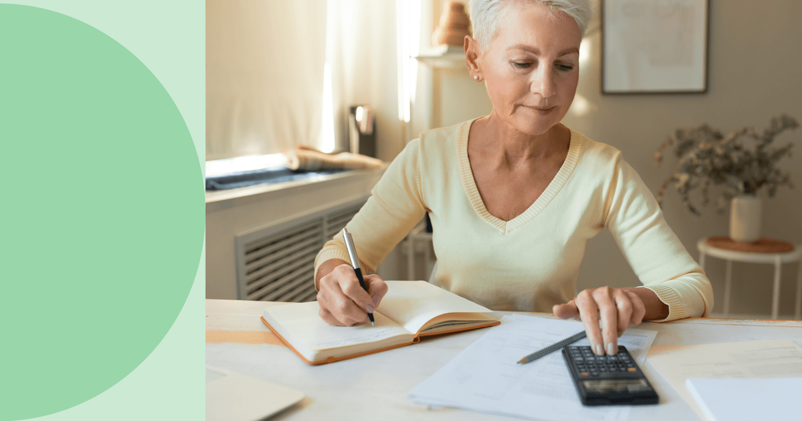 Person Calculating Something on a Calculator with One Hand and Writing in Notebook with Other Hand