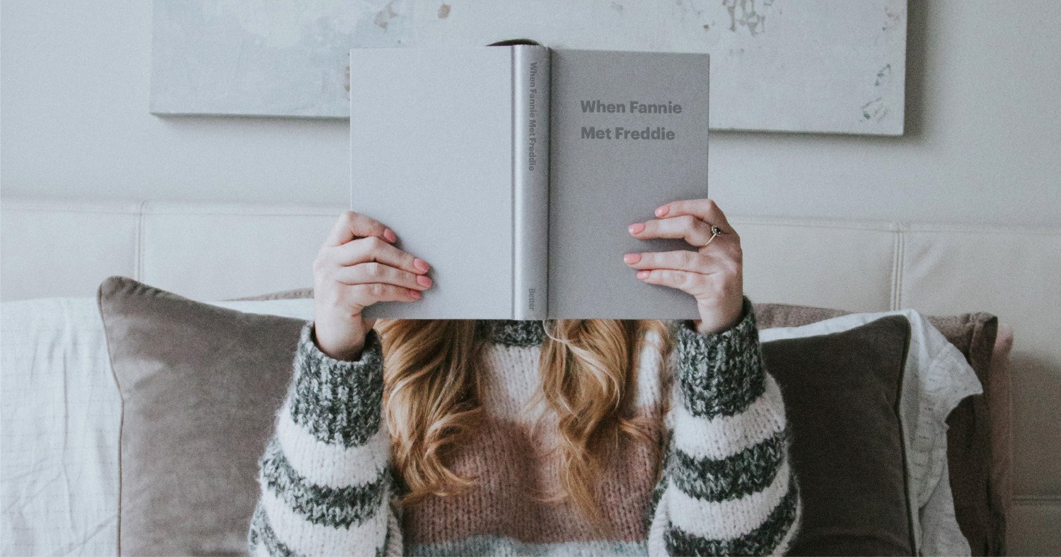 Woman Holding Gray Book Titled When Fannie Met Freddie Over Her Face