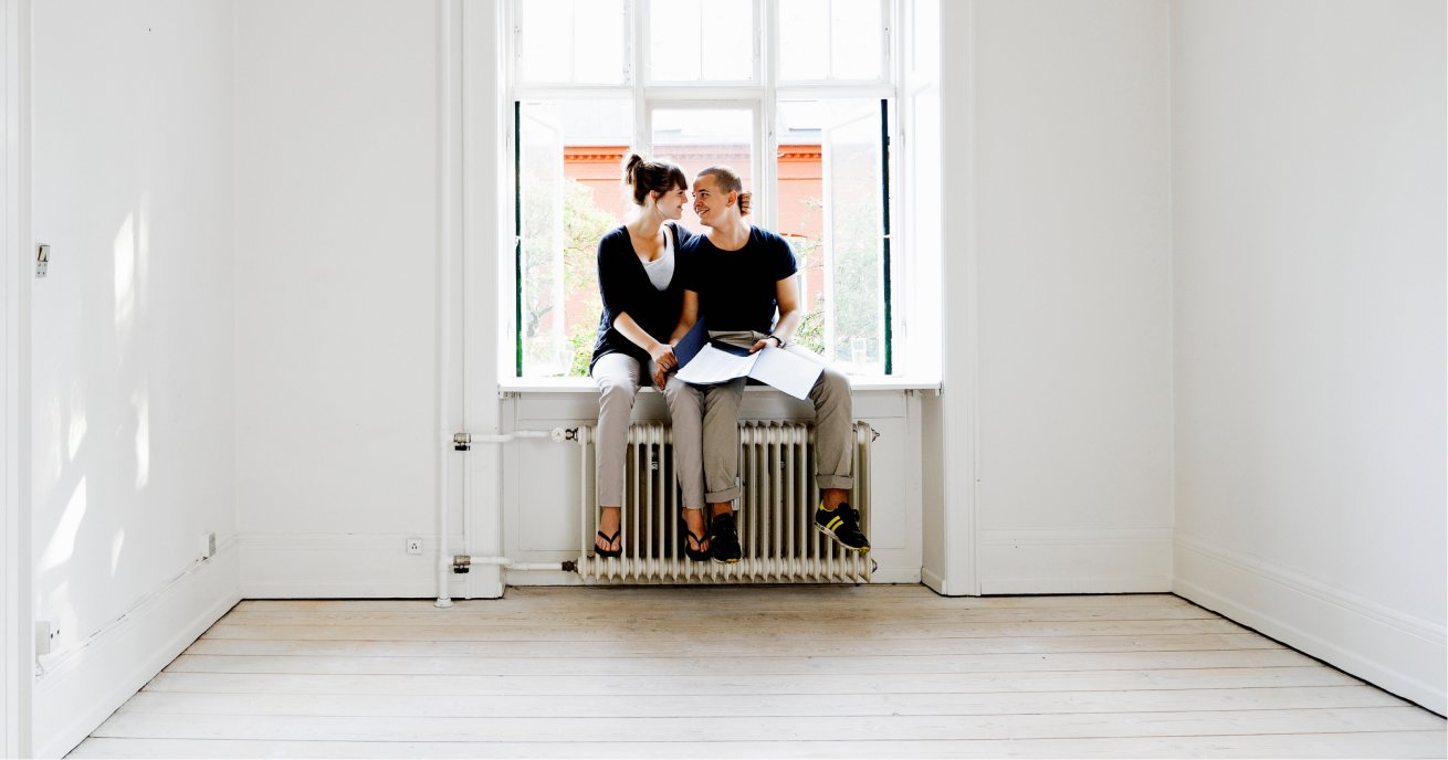 A Couple Sitting on a Window Sill in an Empty Home