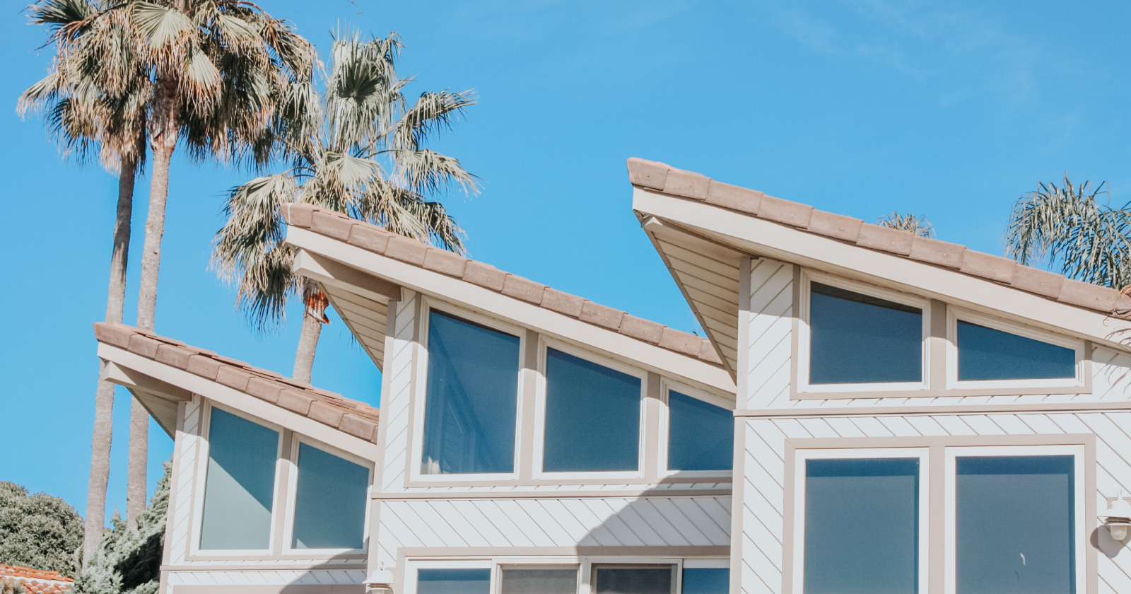 Image of House In Front of Palm Trees and Blue Sky