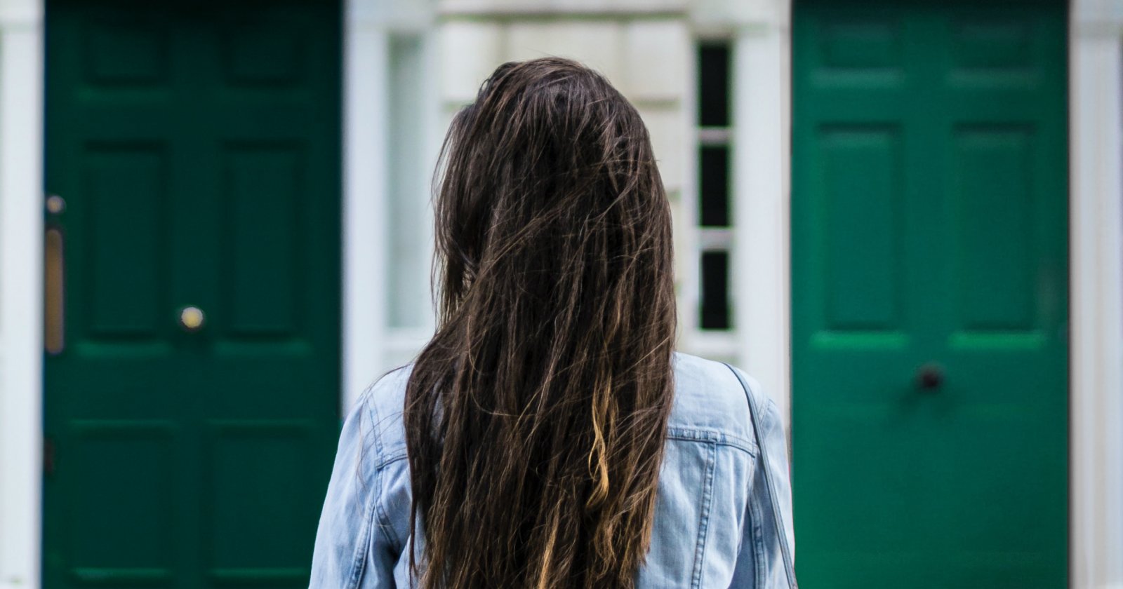 Back of a Person Facing Entrance of Green Doorways