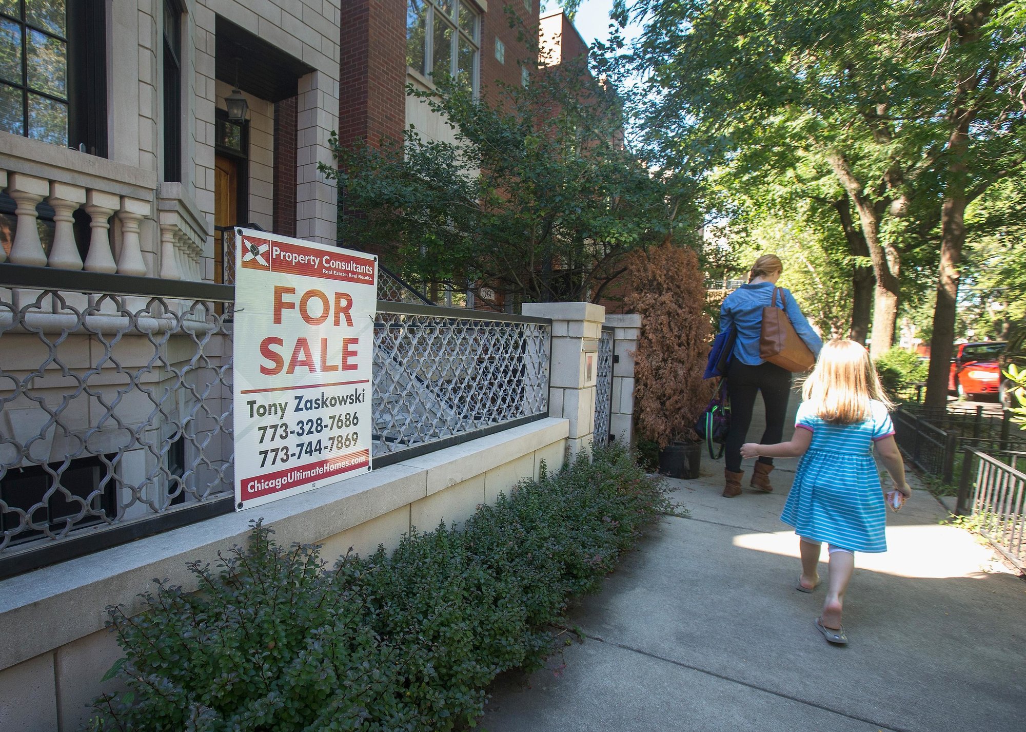 City-street row of homes with a for sale sign - Source: Scott Olson // Getty Images