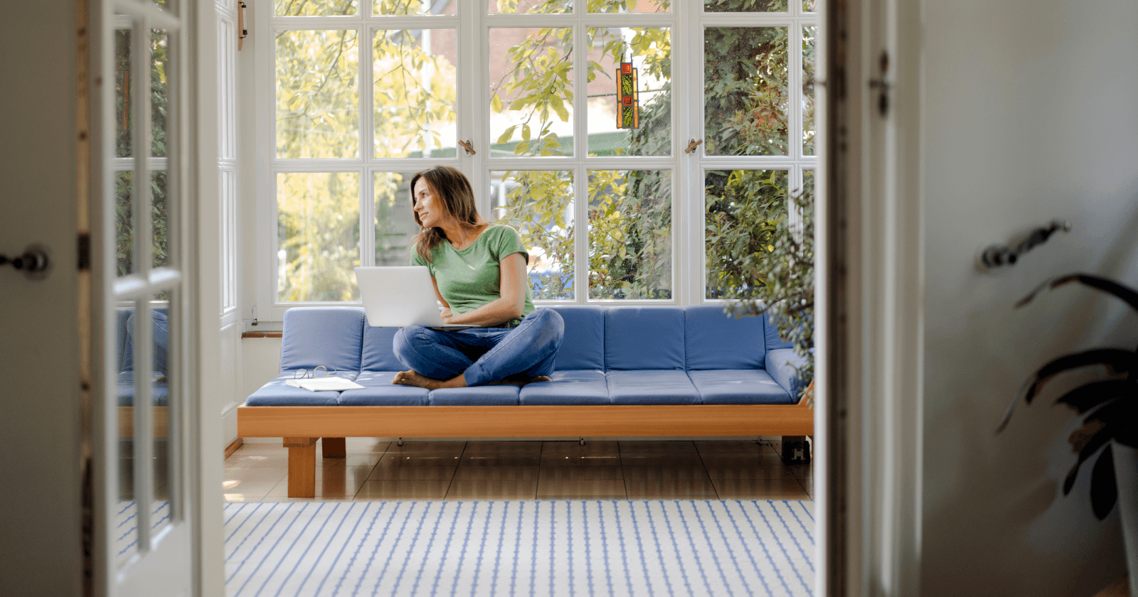 Person Sitting in Sunroom on Laptop