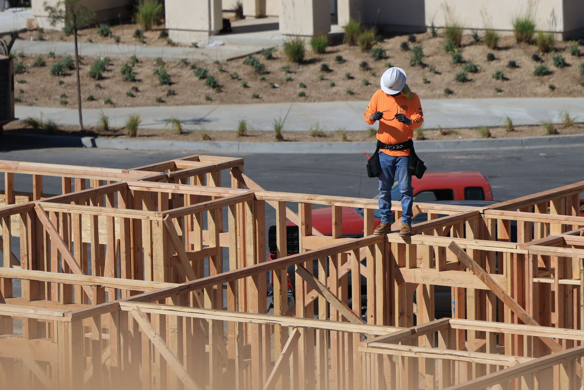 A new home under construction with a construction work walking along the home's frame.