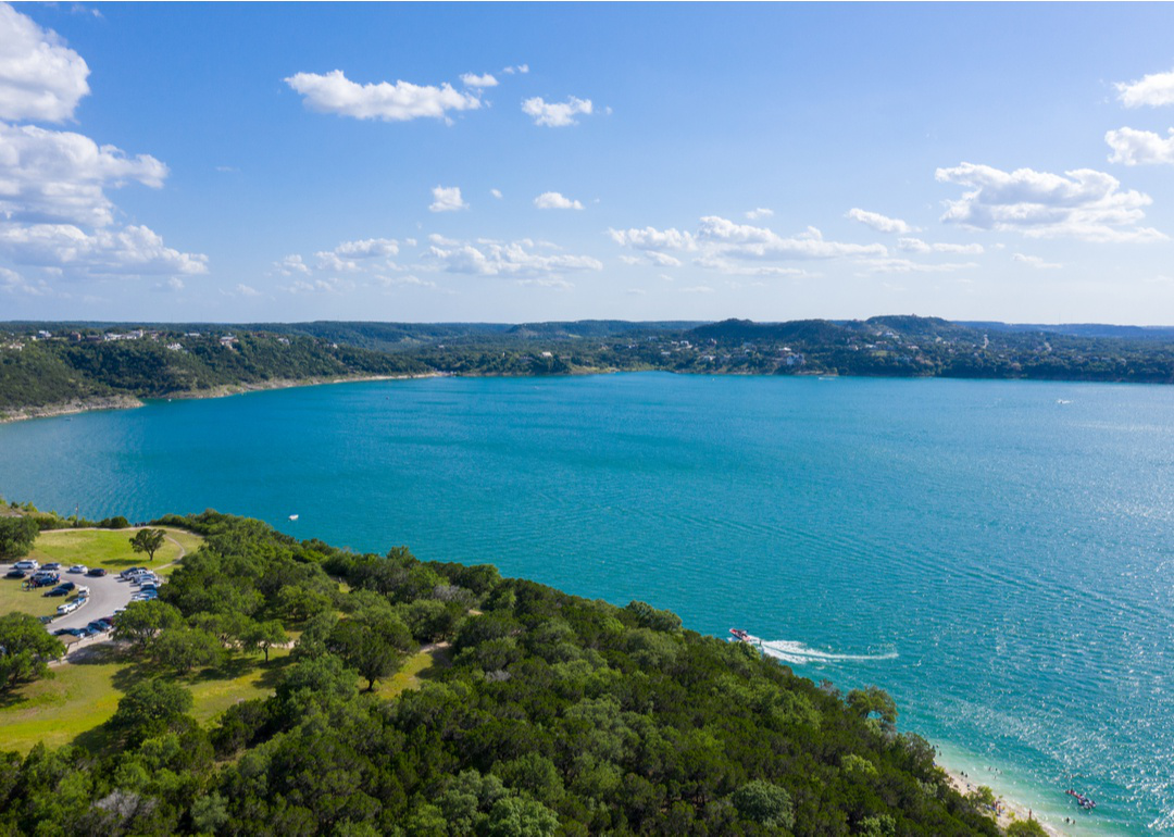 “Photograph of a large lake surrounded by wooded hills” -Source: Dana Rasmussen // Shutterstock