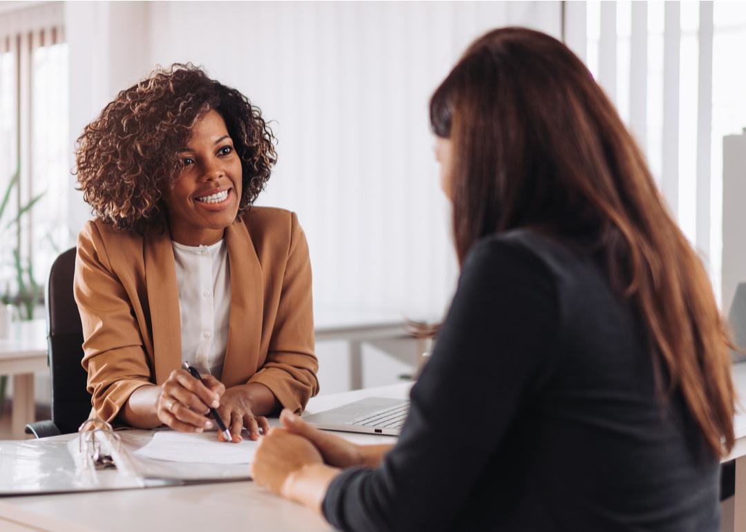 “Photograph of two smiling people reviewing paperwork” - Source: Zivica Kerkez // Shutterstock