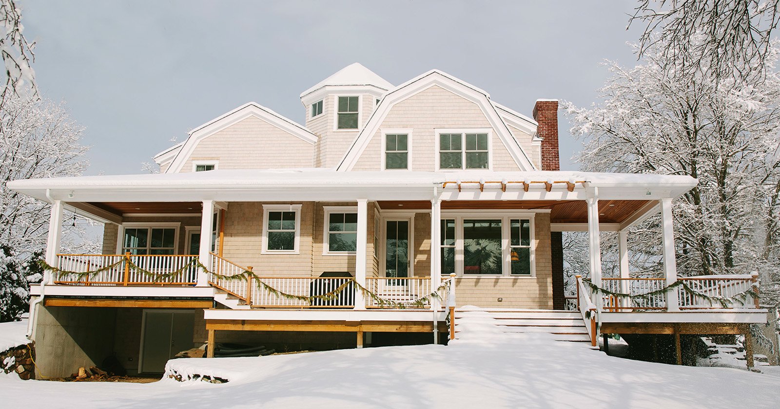 Large Home with Beige Vinyl Siding Surrounded by Snow