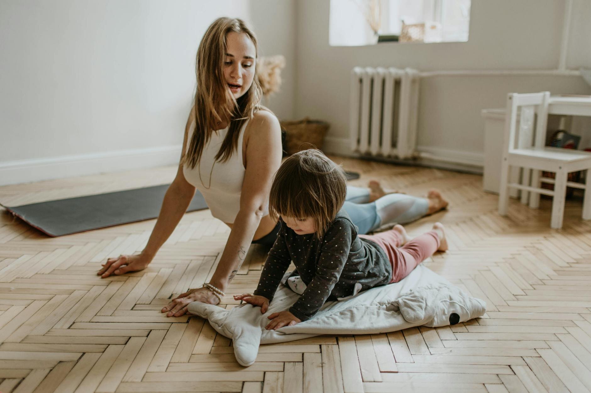 Woman and child practicing yoga in a foreclosed home they just bought.