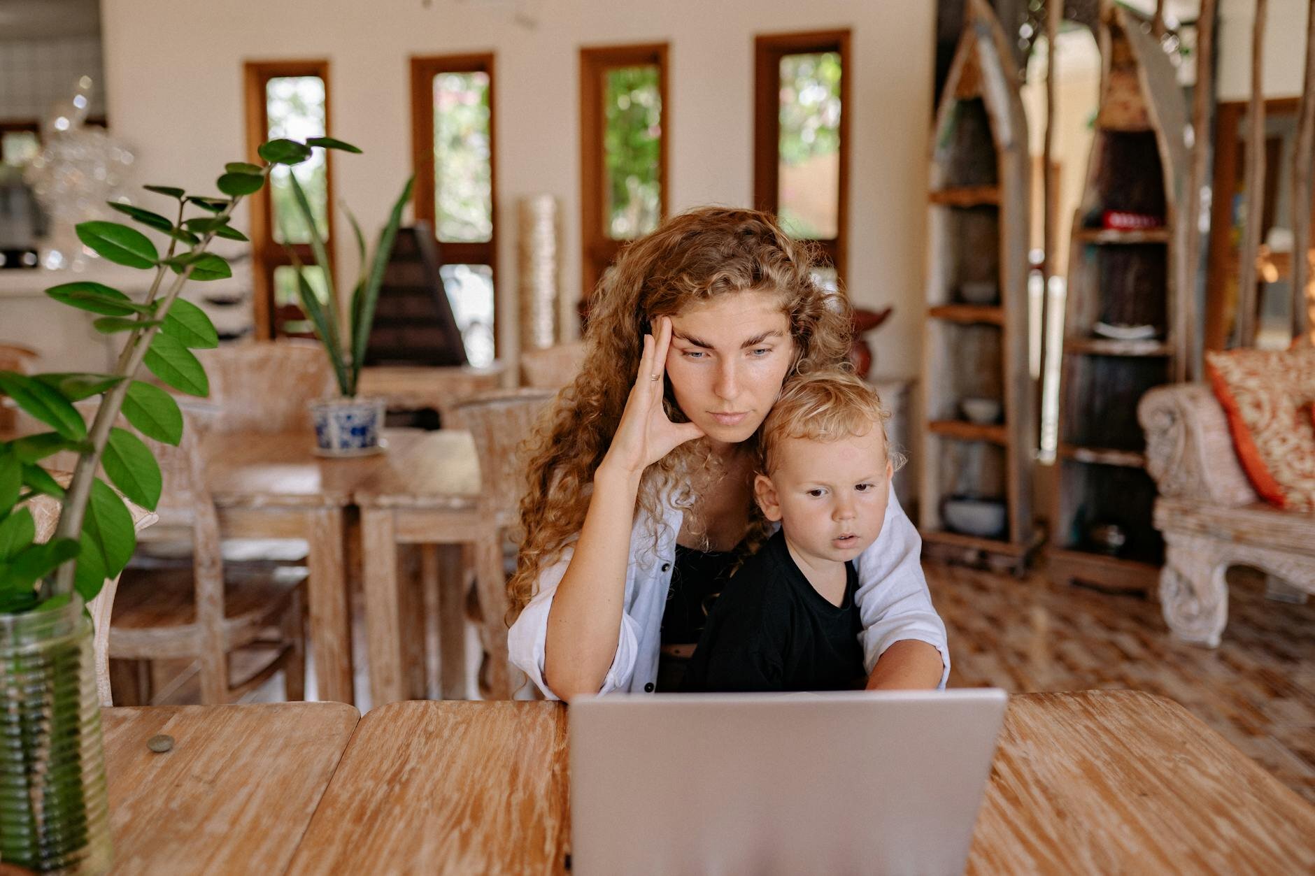 Woman sitting in her home with child learning about the dangers of putting up collateral for a loan.