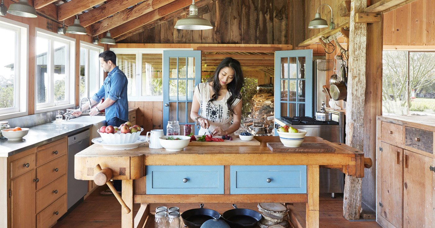  Man and Woman Preparing a Meal in Cabin Style Wood Panelled Kitchen