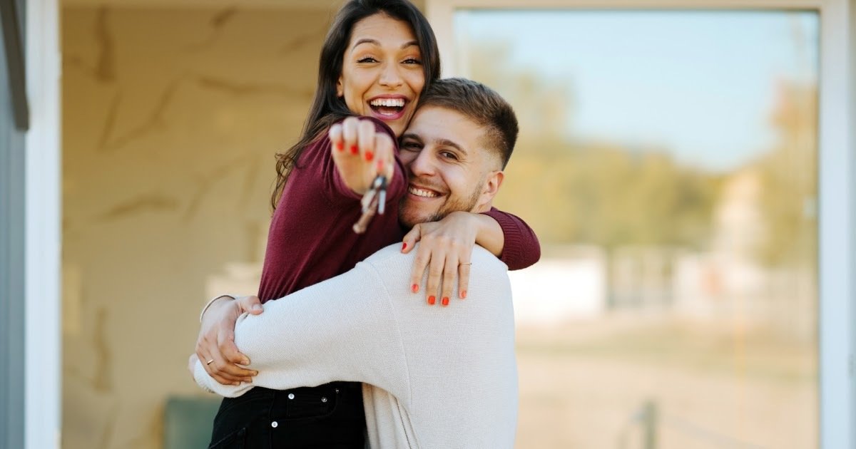 Two People Excitedly Embracing with Keys in Hand