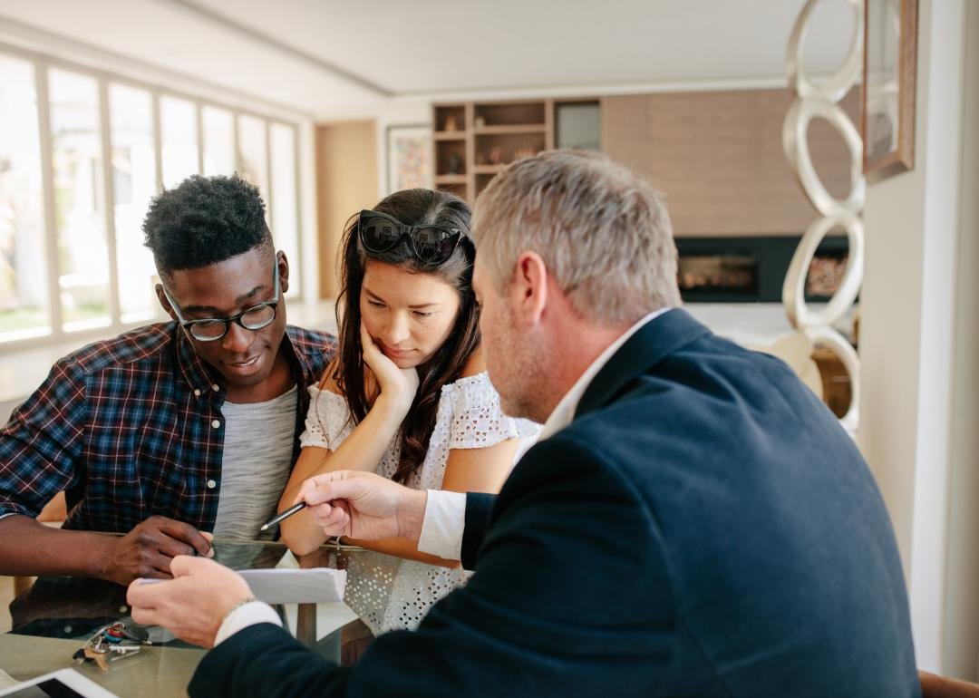  “Photograph of a couple discussing details with a realtor” - Source: Canva