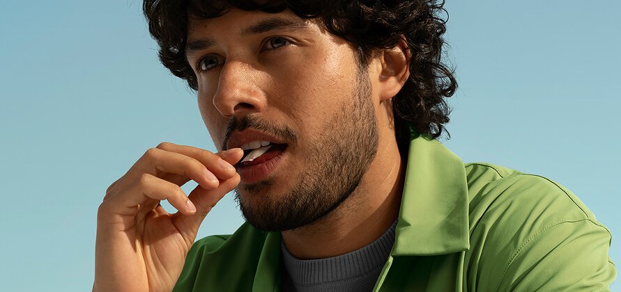 Homme adulte qui place un sachet de nicotine sous la lèvre supérieure