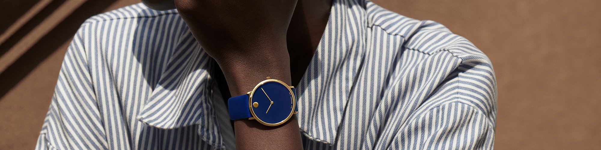Woman wearing a blue Modern 47 watch with leather stap and striped shirt