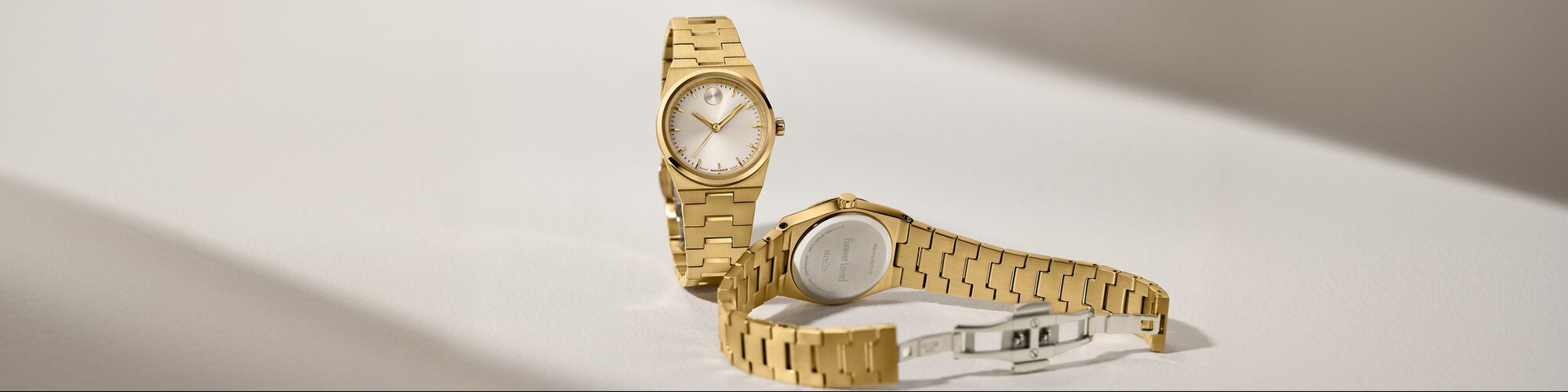 Front and back of a gold tone BOLD Quest Mini bracelet watch. The caseback features personalized engraving that says, "forever loved".