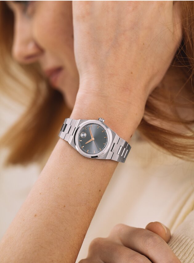 Woman in a white shirt wearing a silver BOLD Quest Mini watch.