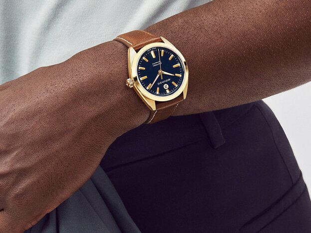 Man wearing the Heritage Datron watch with brown leather strap and blue dial.