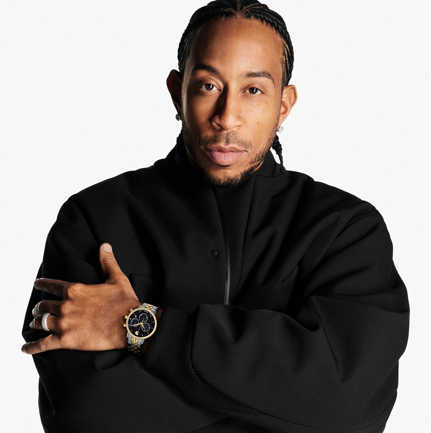 Ludacris in a black outfit wearing a Museum Classic watch with two tone bracelet and black chronograph dial.