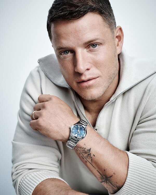 Christian McCaffrey in a quarter zip sweater wearing the stainless steel Museum Imperiale bracelet watch with blue dial