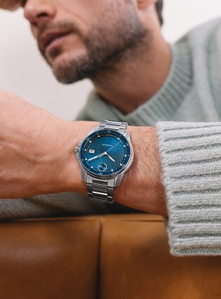 Man in a blue sweater wearing the BOLD Verso automatic watch with stainless steel bracelet and blue dial.