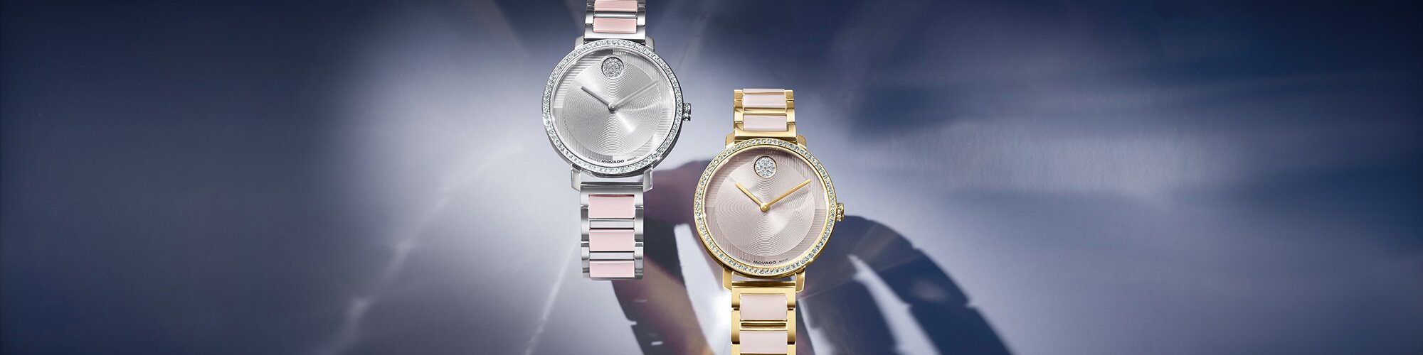 Silver BOLD Evolution 2.0 bracelet watch with pink ceramic in lays and crystal bezel next to a gold tone BOLD Evolution 2.0 bracelet watch with taupe ceramic in lays and crystal bezel.