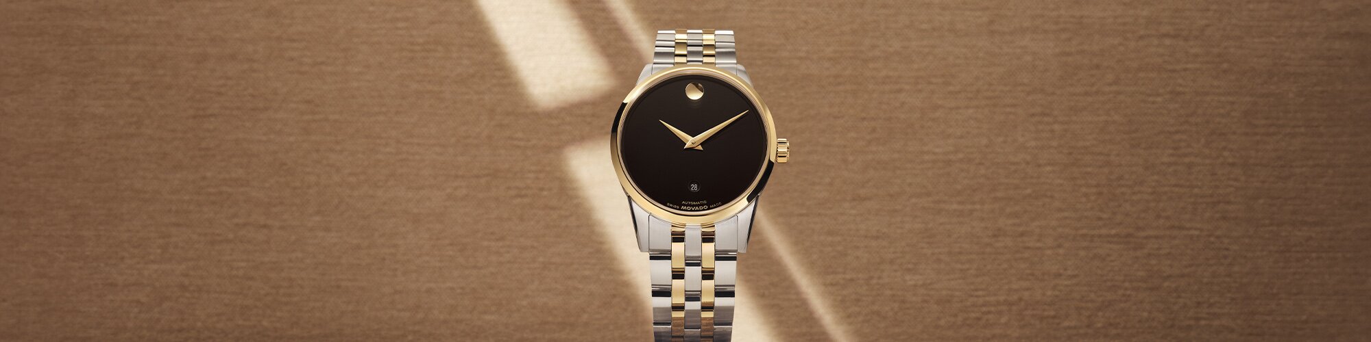 Museum classic watch with two tone bracelet and black dial.
