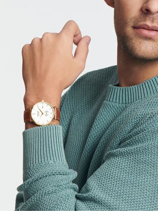 Man in a blue sweater wearing a Heritage Silhouette watch with brown strap and white dial.
