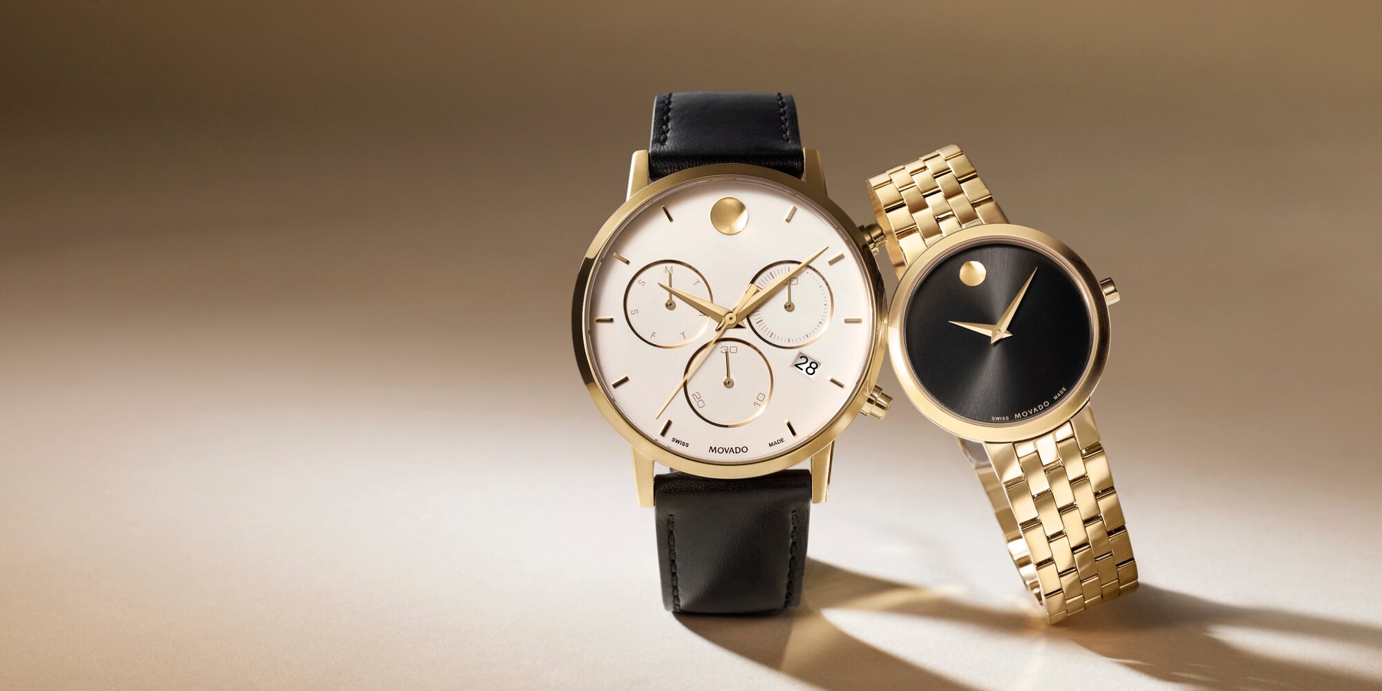 Museum Classic women's watch with gold plated bracelet and black dial next to a men's Museum Classic chronograph watch with black strap and white dial