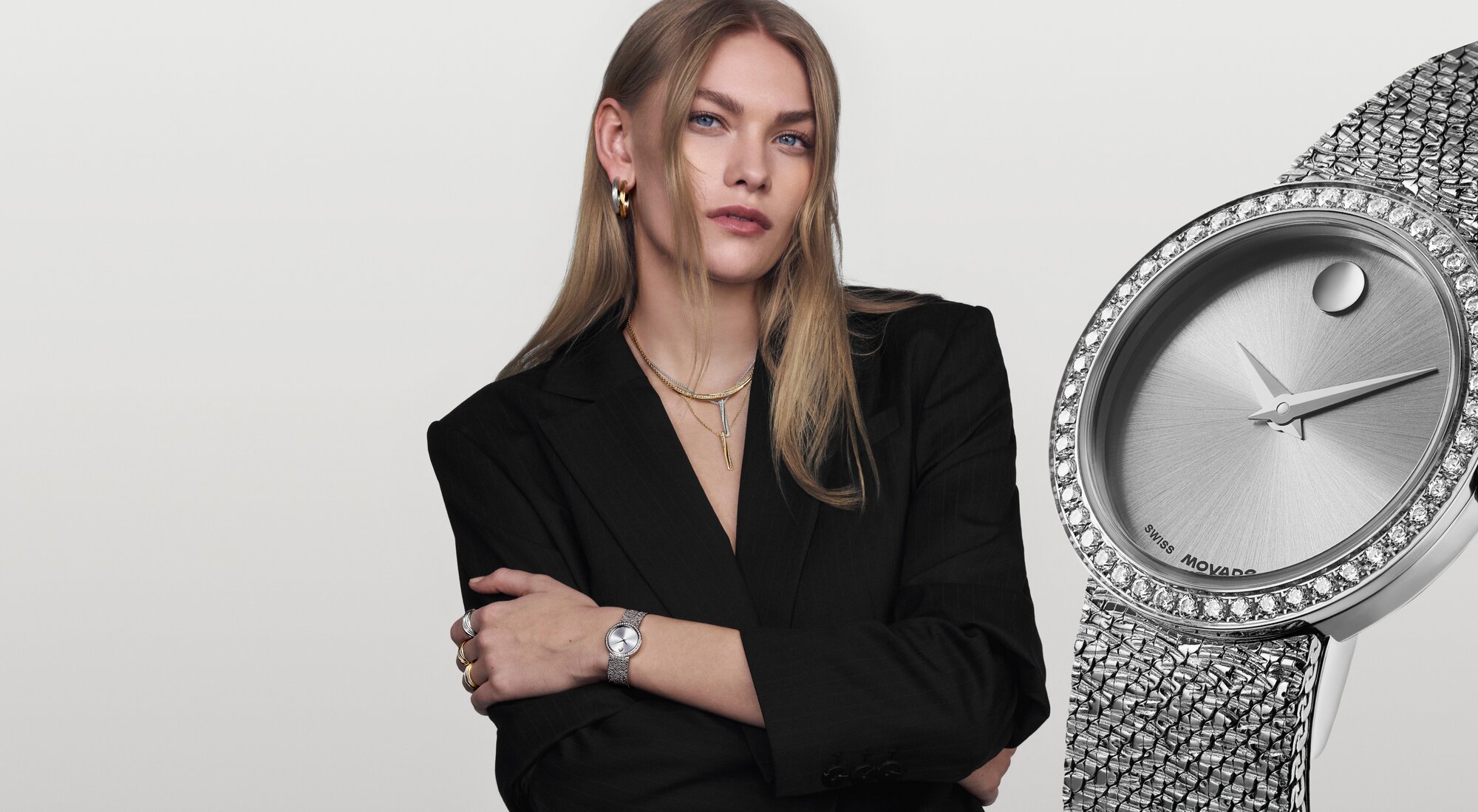 Woman in a black blazer wearing the stainless steel Museum Velura mesh bracelet watch with lab grown dial bezel.