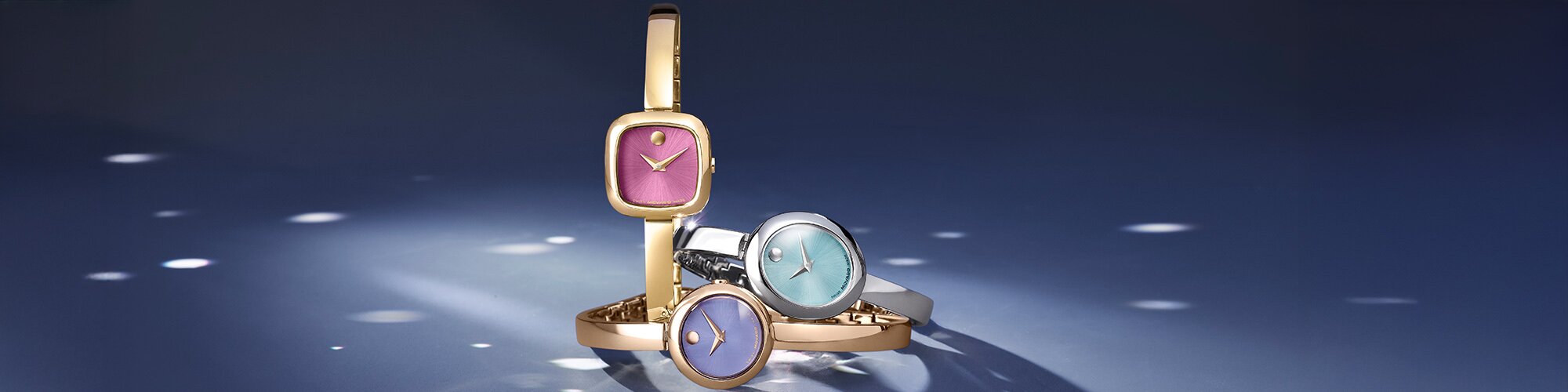 Museum Bangle watches in gold tone with pink dial, rose gold tone with purple dial and silver with blue dial.
